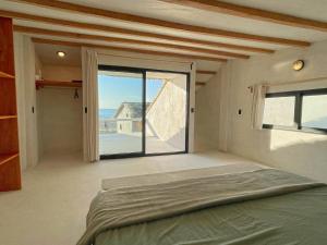 ein Schlafzimmer mit einem Bett und einem großen Fenster in der Unterkunft DOMA - Resort in Guayabas