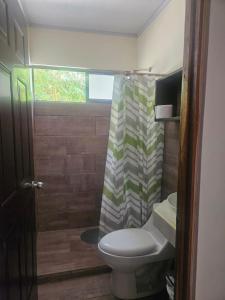 a bathroom with a toilet and a shower curtain at MarLis in Quebrada Seca