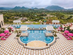 a view of a pool with chairs and a resort at Fairmont Udaipur Palace in Udaipur
