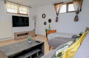 a living room with a couch and a tv at Oleander Garden in Alexandroupoli
