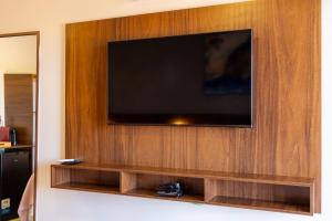 a flat screen tv mounted on a wooden wall at Pousada do Nica in Fernando de Noronha