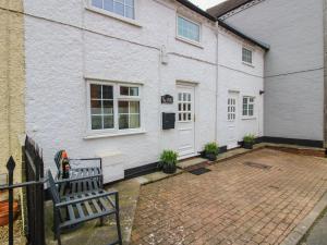 a house with a bench in front of it at Cariad Cottage in Ludlow