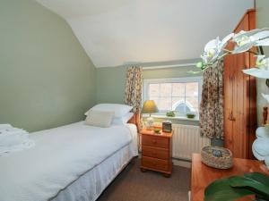 a bedroom with a bed and a window at Cariad Cottage in Ludlow