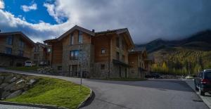 a house on the side of a road next to a mountain at Chalets Jasná Centrum APARTMENT M - Free Jacuzzi & Sauna and Chopok view in Belá