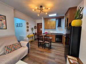 a living room and kitchen with a couch and a table at APARTAMENTO ALECRIN Padrón in Padrón