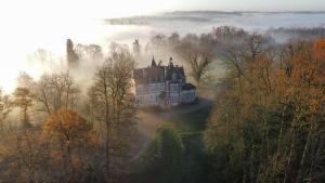 an old castle in the middle of a foggy forest at Château de la Redortière in Lézignac-Durand