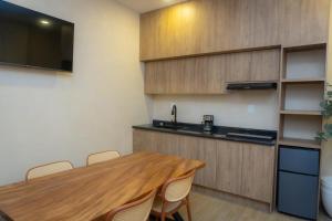 a kitchen with a wooden table with chairs and a sink at Hotel & hostal Morada in Puebla