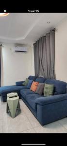 a blue couch with pillows on it in a living room at Oasis de Moanda 1 in Libreville