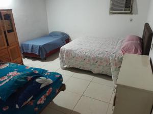 a room with two beds and a table and a bedskirts at La Petite Maison Mariano Casa in Limpio