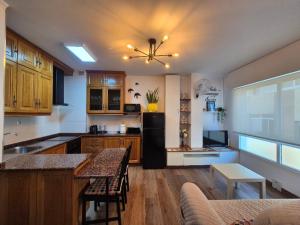 a kitchen with wooden cabinets and a black refrigerator at APARTAMENTO ALECRIN Padrón in Padrón