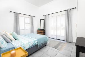 a bedroom with a bed and a mirror and windows at The North Atlantic Sands Beach House in Velddrif