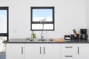 a kitchen counter with a sink and a window at The North Atlantic Sands Beach House in Velddrif