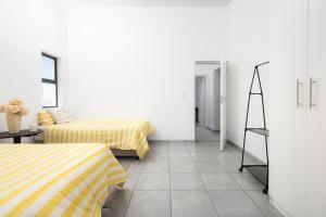 a white room with two beds and a mirror at The North Atlantic Sands Beach House in Velddrif