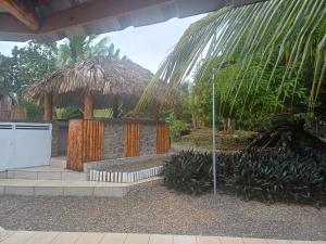 a gazebo with a palm tree and a building at Casa Alegiu in Las Galeras