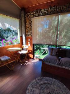 ein Schlafzimmer mit einem Bett, einem Tisch und einem Fenster in der Unterkunft Alojamiento el Arrayán in Temuco