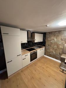 a kitchen with white cabinets and a stove at Haus am Freilinger See Bar in Blankenheim
