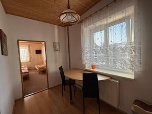 a dining room with a table and chairs and a window at Penzion Emílie in Jeseník
