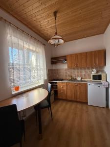 a kitchen with wooden cabinets and a table and a window at Penzion Emílie in Jeseník +19 photos