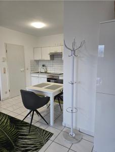 a white kitchen with a table and a chair at Apartment Kliniknähe in Idar-Oberstein