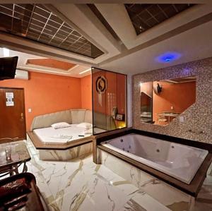 a large bathroom with a tub and a bed at Cida ou Lara in Aparecida de Goiânia