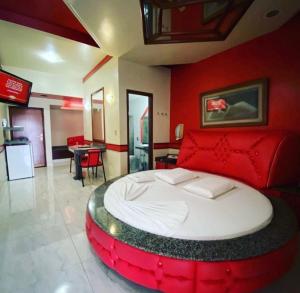 a bedroom with a large bed with red walls at Cida ou Lara in Aparecida de Goiânia