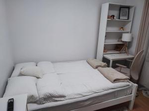 a white bed with pillows on it in a room at Apartament Abby in Sighişoara