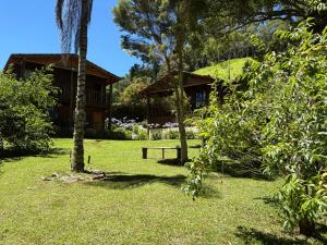 a house with a picnic table in the yard at Pousada São Miguel Natureza e Descanso em Cunha SP in Cunha