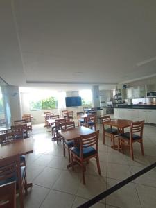 ein Esszimmer mit Tischen und Stühlen und eine Küche in der Unterkunft Hotel Milla in Teixeira de Freitas