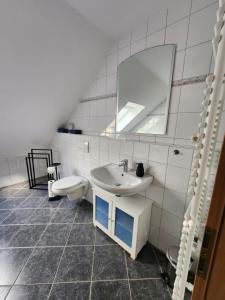 a white bathroom with a sink and a mirror at Ferienwohnung Fröse in Altenbeken +33 photos
