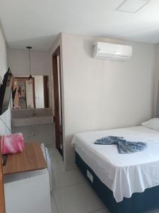 ein kleines Schlafzimmer mit einem Bett und einem Spiegel in der Unterkunft Hotel Milla in Teixeira de Freitas