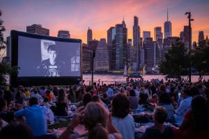 a crowd of people watching a movie on a screen at Now Now NoHo in New York +18 photos
