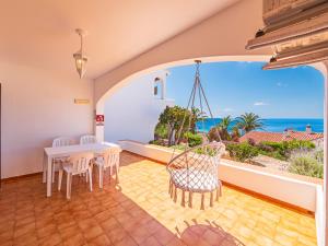 a dining room with a table and chairs and the ocean at Alta Mar Apartment by 3VILLAS in Son Bou