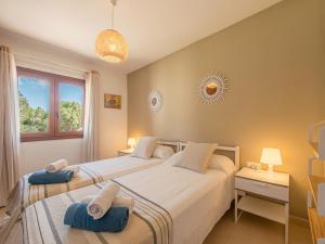 two twin beds in a bedroom with a window at Alta Mar Apartment by 3VILLAS in Son Bou