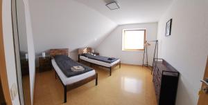a living room with two beds and a window at Ferienwohnung Fröse in Altenbeken
