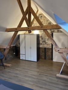 a room with a white refrigerator in a loft at Haus am Freilinger See Bar in Blankenheim