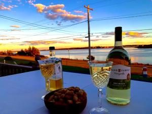 a bottle of wine and glasses on a table with a bowl of nuts at 101 Harborview Drive in North Rustico +12 photos