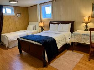 a hotel room with two beds and two windows at 101 Harborview Drive in North Rustico