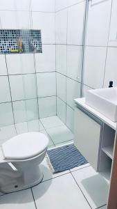 a white bathroom with a toilet and a sink at Casa familiar perto da Escola São Cristovão in Garanhuns