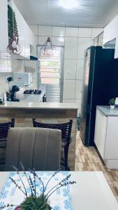 a kitchen with a table and a refrigerator at Casa familiar perto da Escola São Cristovão in Garanhuns