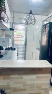 a kitchen with a refrigerator and a counter top at Casa familiar perto da Escola São Cristovão in Garanhuns