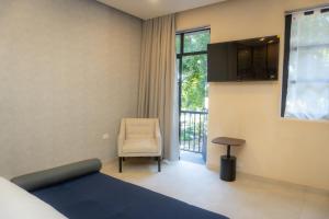 a bedroom with a bed and a chair and a window at Hotel & hostal Morada in Puebla