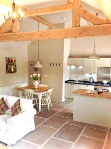 a kitchen and a living room with a table and a kitchen at Winnow Barns Holidays in Ashbourne