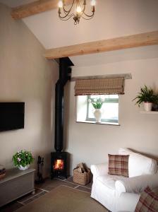 a living room with a couch and a fireplace at Winnow Barns Holidays in Ashbourne