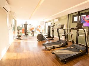 a gym with treadmills and elliptical machines at Campos Sales by Xtay - Studios completos na região judiciária de Juvevê in Curitiba