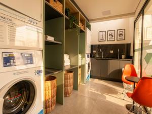 a laundry room with a washer and dryer at Campos Sales by Xtay - Studios completos na região judiciária de Juvevê in Curitiba