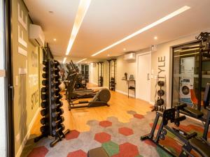 a gym with treadmills and exercise equipment in a room at Campos Sales by Xtay - Studios completos na região judiciária de Juvevê in Curitiba