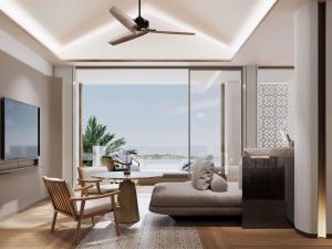 a living room with a couch and a ceiling fan at Navera Phuket - MGallery Collection in Surin Beach