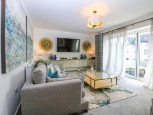 a living room with a couch and a table at 2 Glan Yr Aber in Colwyn Bay