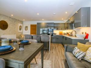 a kitchen and living room with a wooden table at 2 Glan Yr Aber in Colwyn Bay