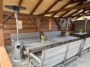 a patio with wooden benches and a table and two tables at Jedlinka in Palota